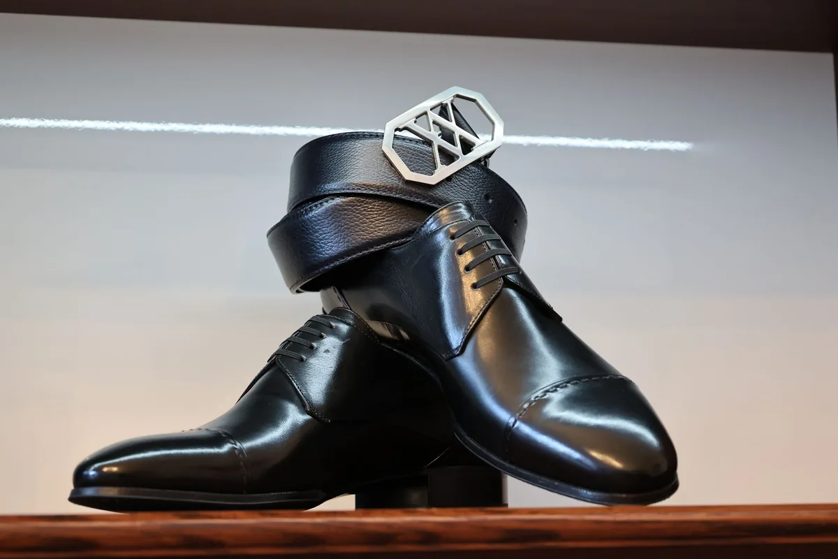 Classic black leather shoes paired with a matching belt in a stylish arrangement.